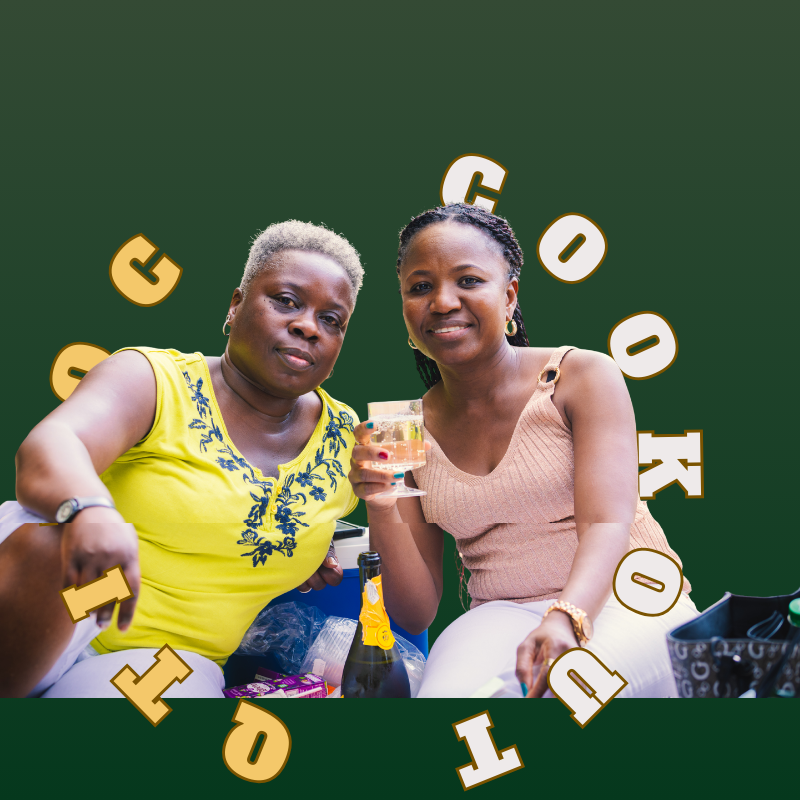Two women raising glasses together at the CookOut